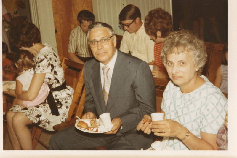 Man and woman pose for photo with refreshments