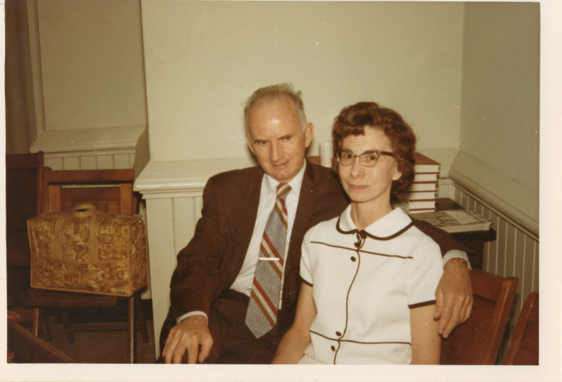 Man poses with his arm around a woman