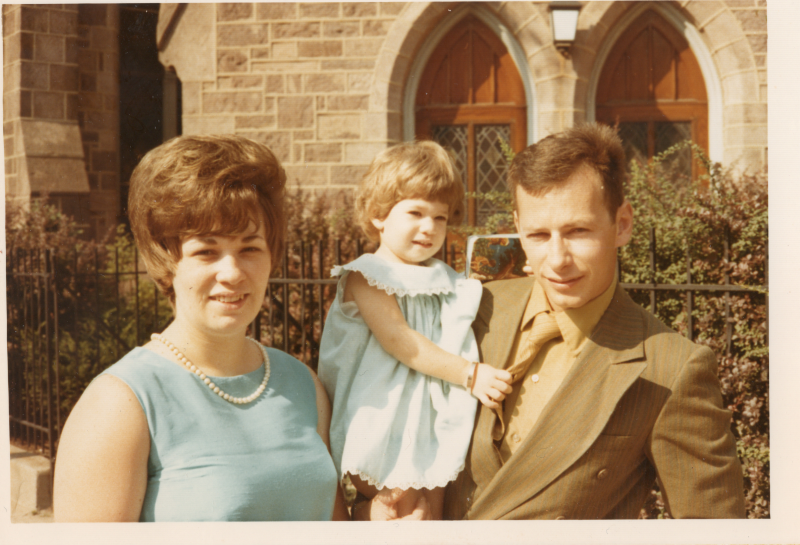 Man and woman pose with a baby outside of the church at 18th and Spring Garden Streets