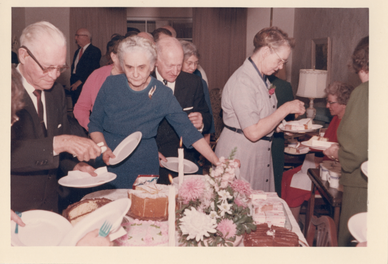 A line of people serve themselves desserts