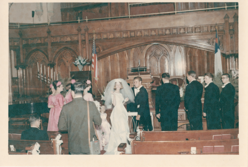 Bride and groom speak surrounded by wedding party