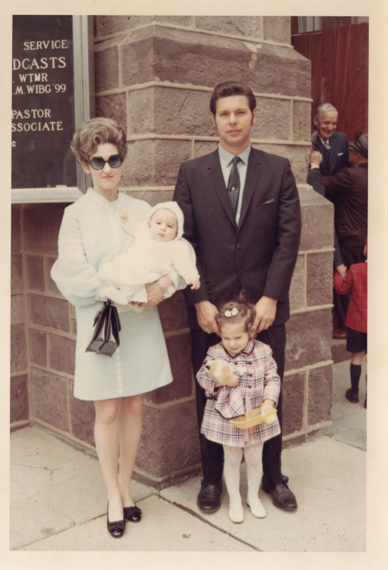A man, woman, child, and baby outside of the building at 18th and Spring Garden Streets