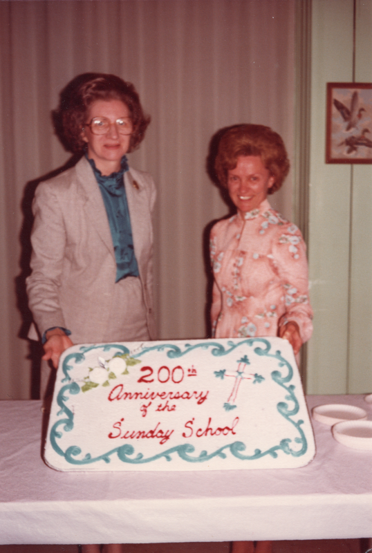 Betty Roberson and a woman pose with a cake that reads "200th Anniversary of the Sunday School"