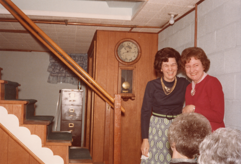 Two women smile arm-in-arm
