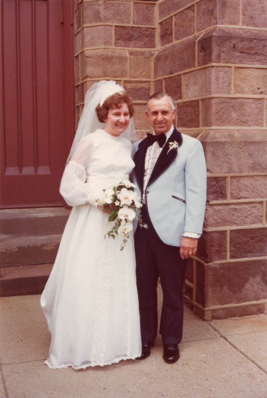 A bride poses with a man outside the building at 18th and Spring Garden streets