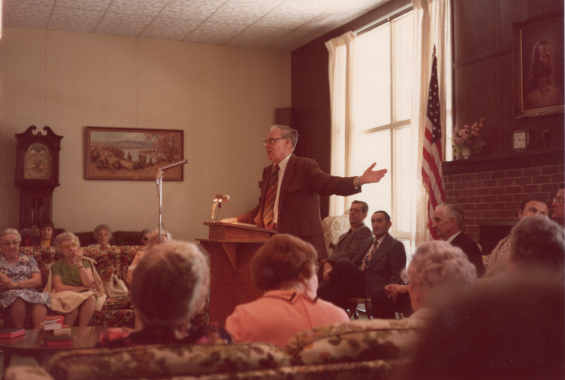 A man addresses an older audience