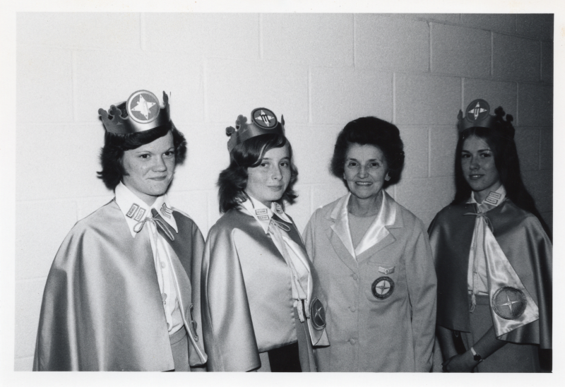 Three missionettes and an adult leader pose for a photograph