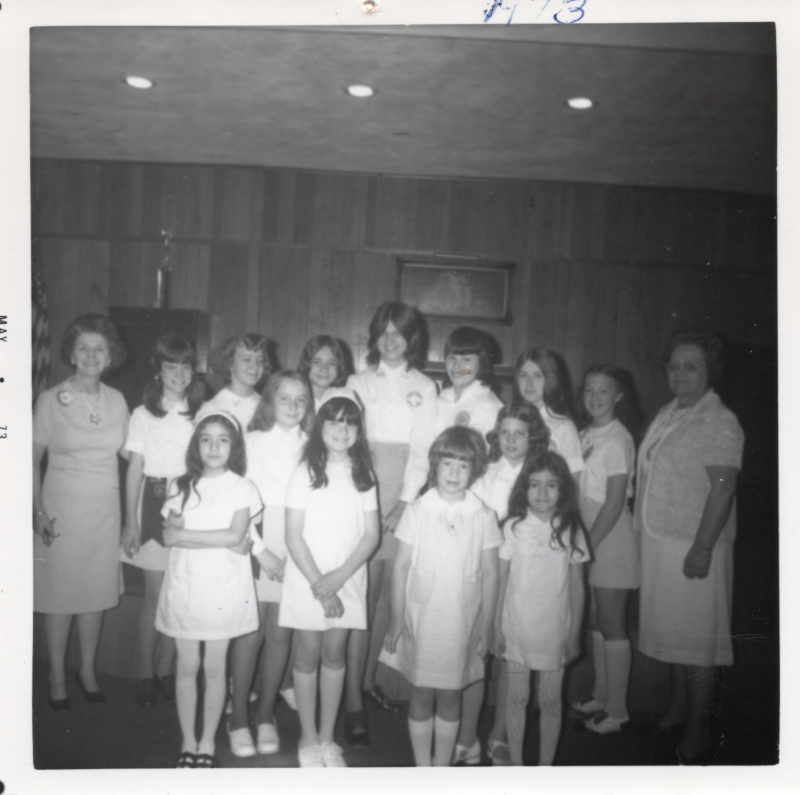 Adult missionette leaders stand with young girls
