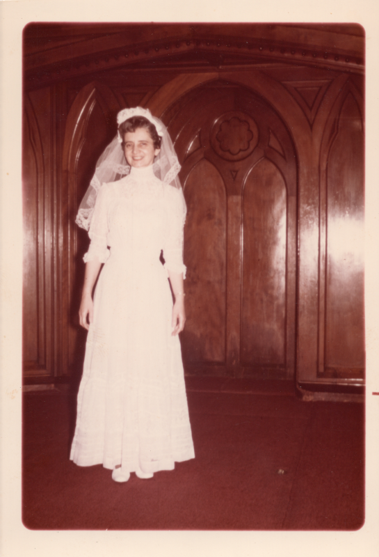 A young woman poses for a photo in the sanctuary in a wedding gown and veil