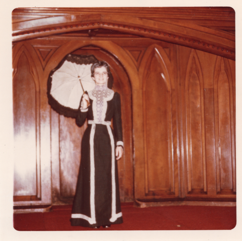 A woman in a black dress and parasol on the sanctuary stage