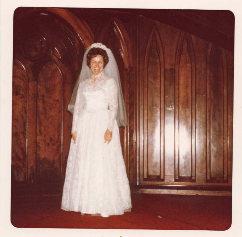 A woman poses on the sanctuary stage in a wedding gown