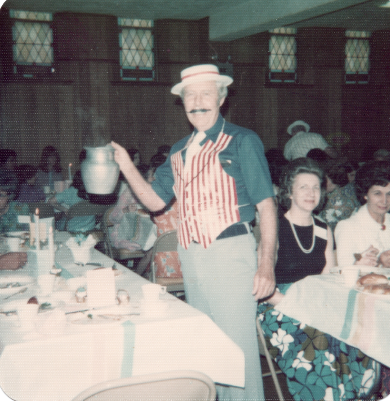 A man dressed in barbershop style pours water for tables of congregants