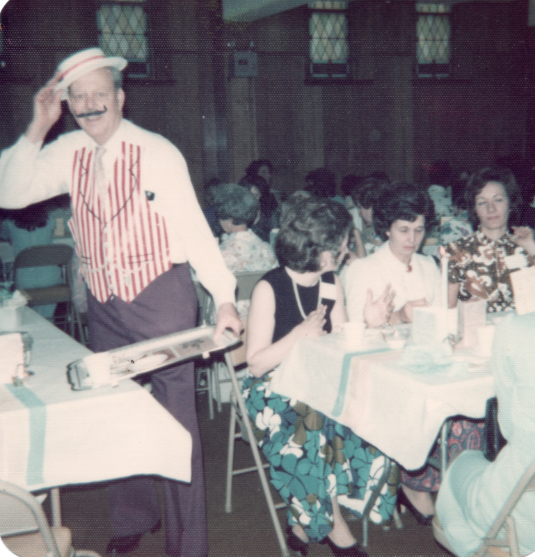 A man dressed in barbershop style poses as he serves tables of congregants