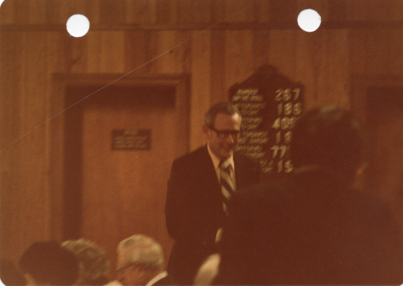 A man stands to greet other congregants