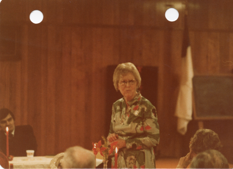 A woman stands at a table