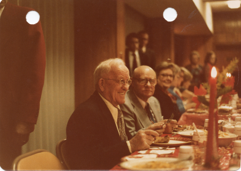 A man smiles while dining with others