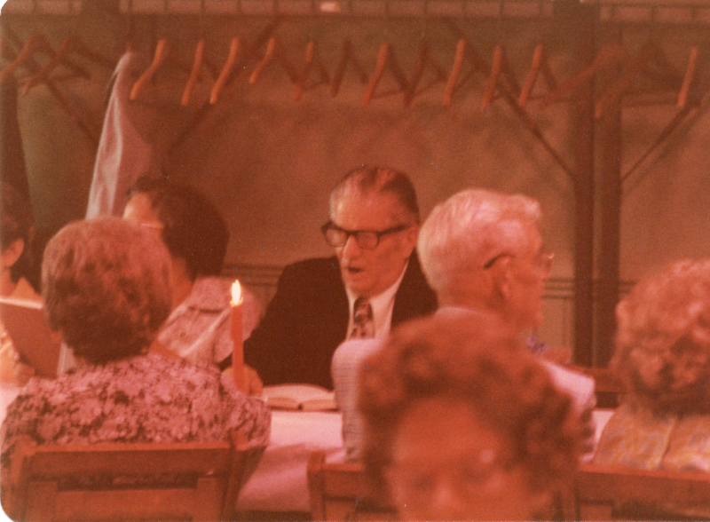 Congregants dining together open their hymnals to sing