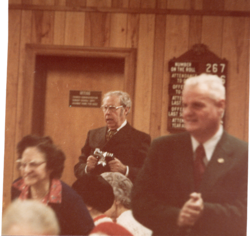 A man walks around a fellowship event with a camera