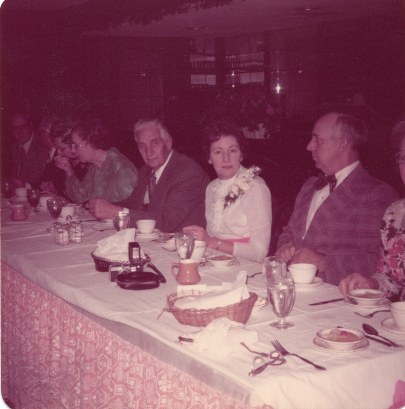 Pastor Roberson sits at a table with a group of people over a meal