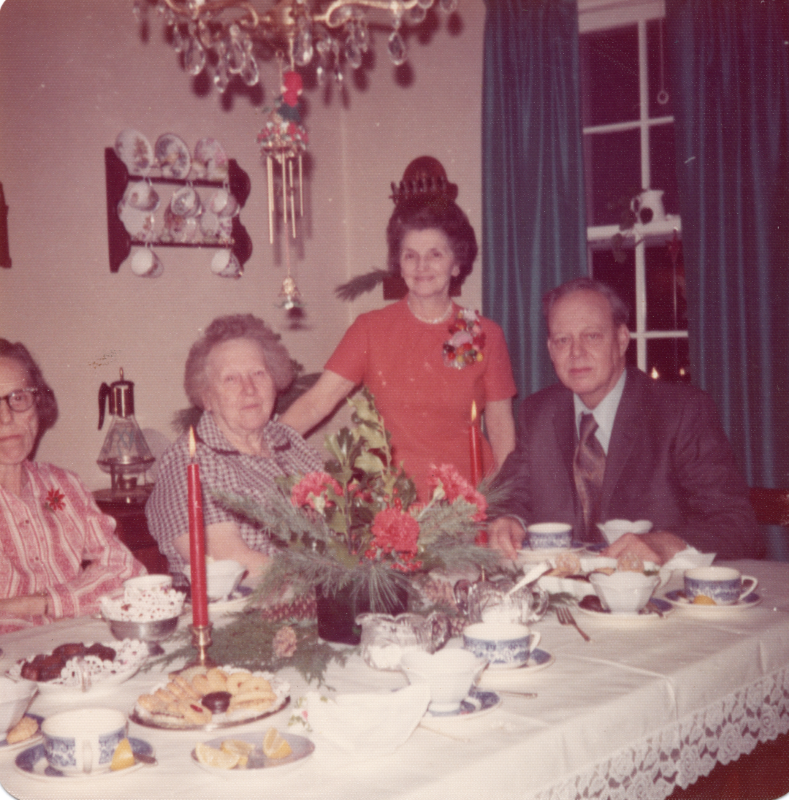 Three women and a man smile for a photograph