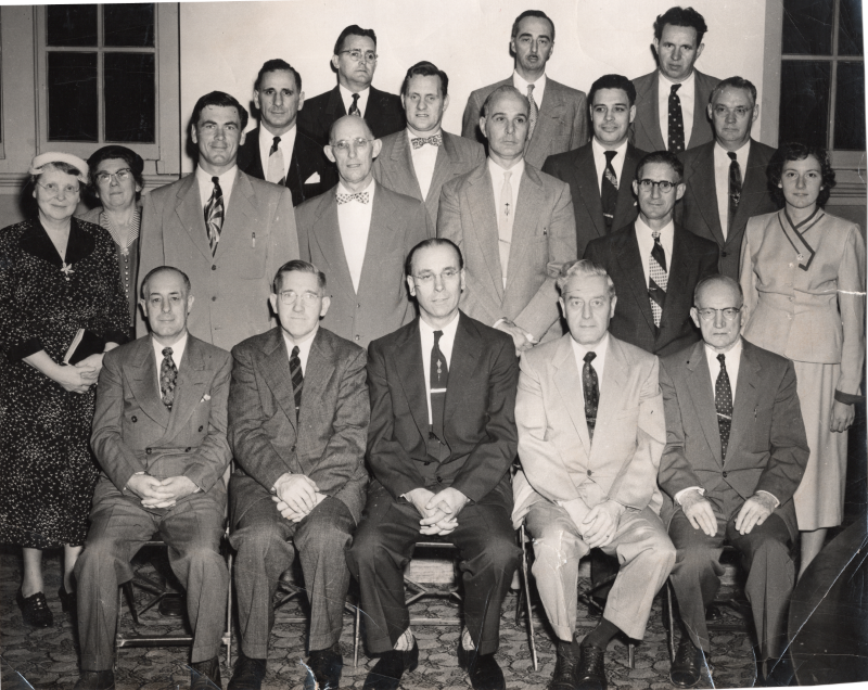 Seventeen men and three women pose together for a portrait