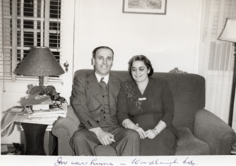 Pastor and Mrs. Bragg smile for a portrait with a caption reading, "In our home"