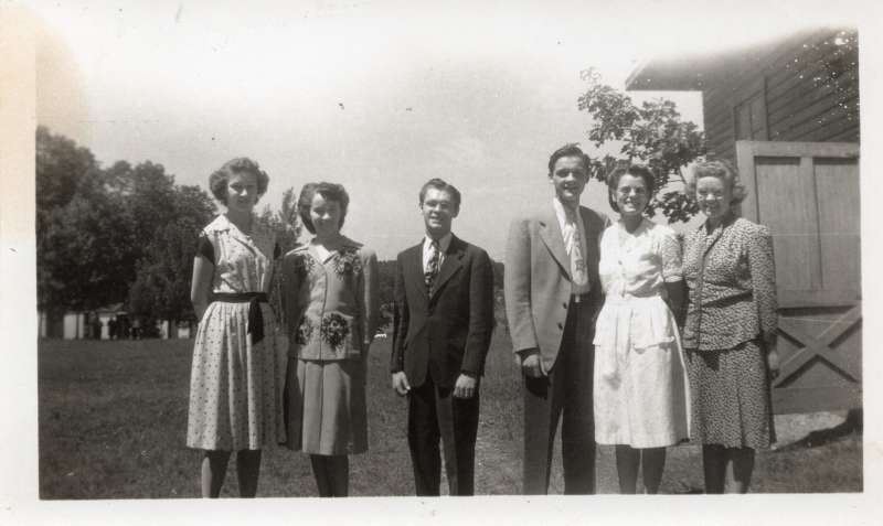 Four women and two men pose together for a portrait
