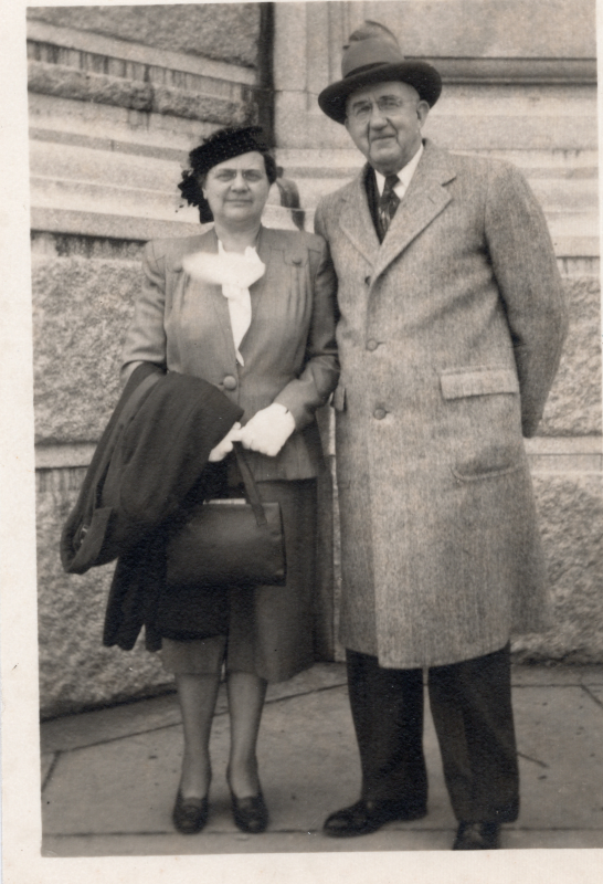A man and woman smile together outside