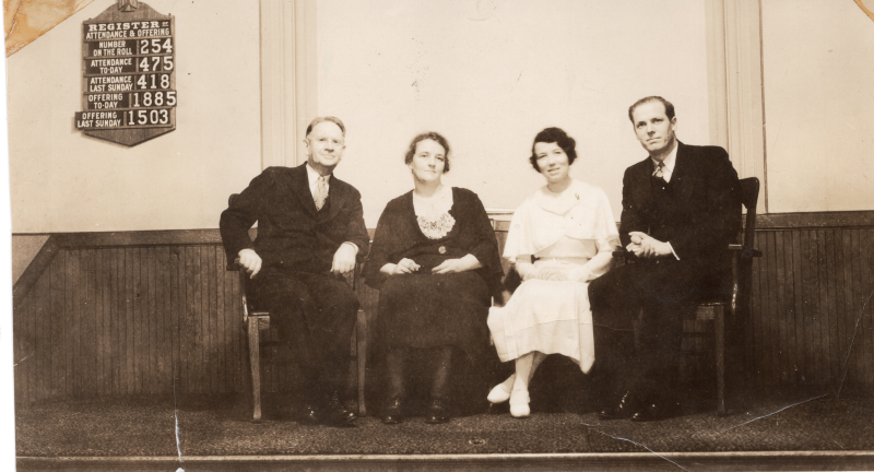 Two men and two women smile with the church register