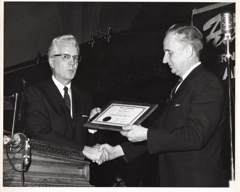 A man presents Highway Tabernacle and Pastor Roberson an Honor of Organization plaque