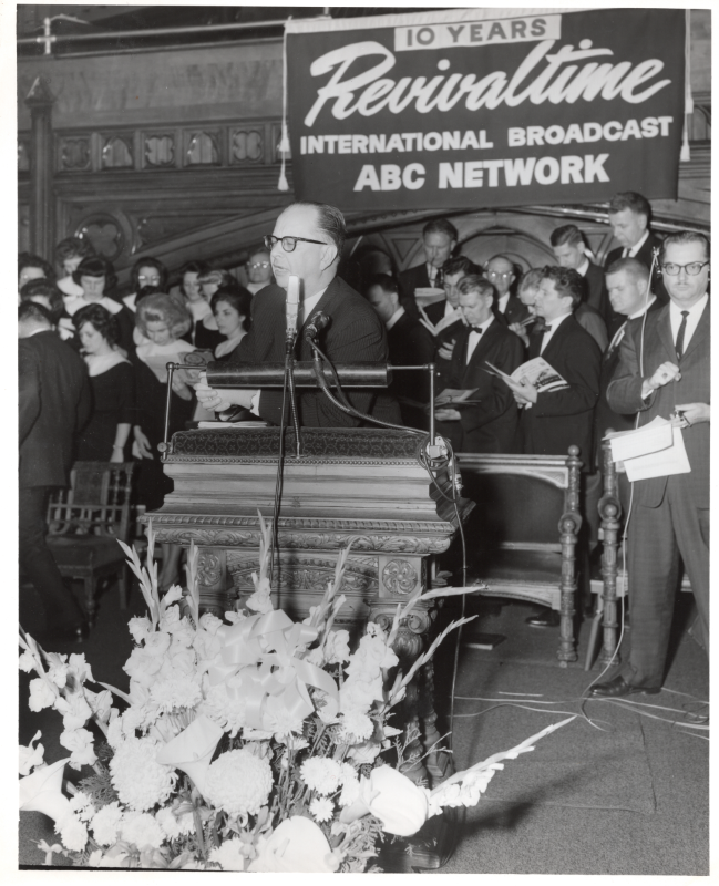A man speaks at the pulpit on the Revivaltime radio broadcast