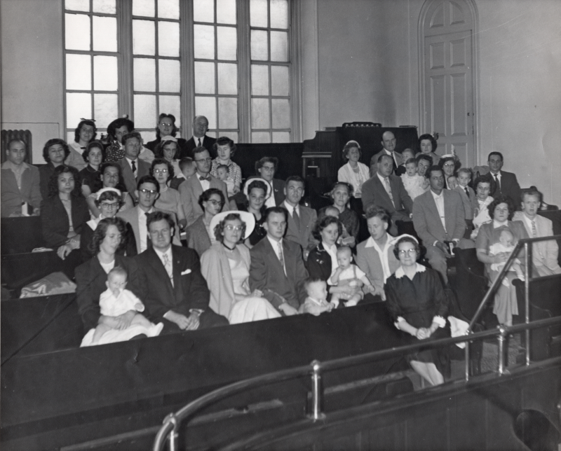 Members of the congregation look at a camera in the balcony for a photograph