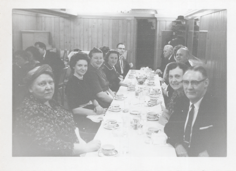 Portrait of a group of people seated around a table dining together