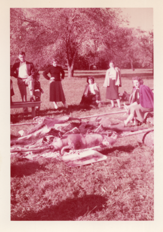 Members of the choir stand around roasting pigs