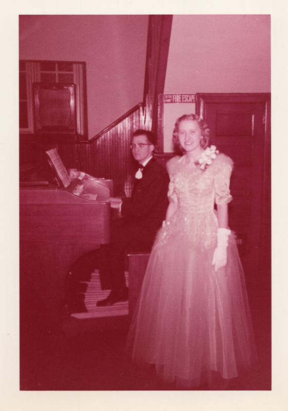 Walter plays the organ in a tuxedo as Alta smiles for a photograph in a formal gown