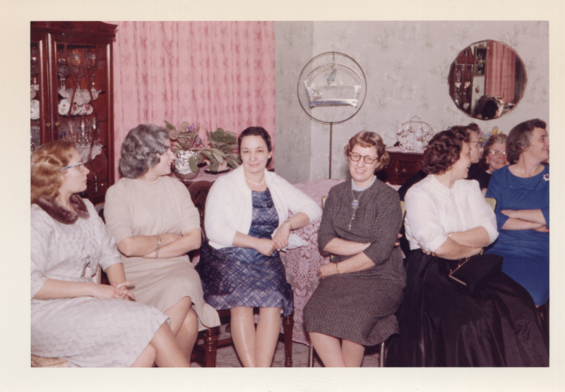 A group of women sit together in a living room