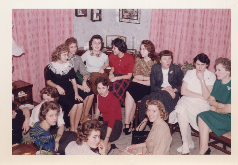 A group of women sit together in a living room