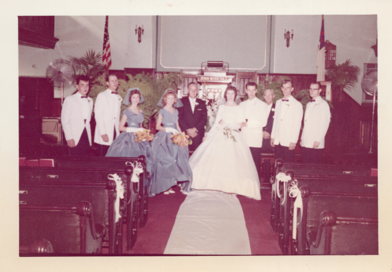 A bride and groom in a sanctuary pose with their wedding party