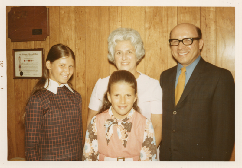 Two children, a man, and a woman smile together for a portrait
