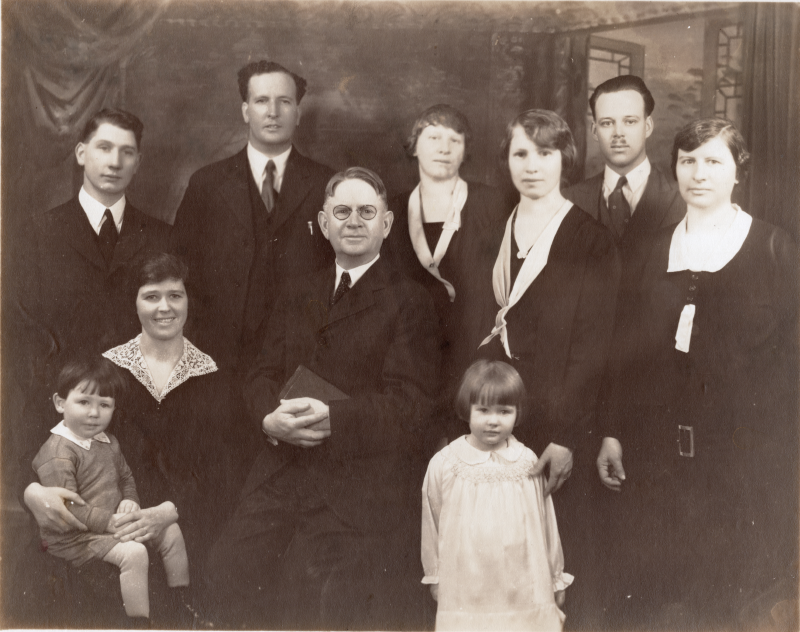 Portrait of the Van Meter family with Rev. Van Meter seated in the first row holding a Bible