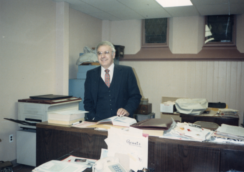 Pastor Bogdan stands with boxes of paperwork next to a copy machine