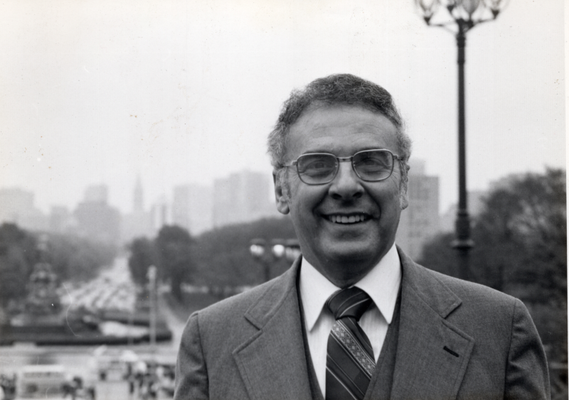 Pastor Bogdan smiles for a photograph outside the Philadelphia Museum of Art with City Hall in the background