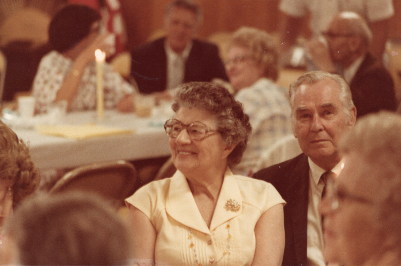 A woman smiles next to a man looking at the camera for a photograph at a fellowship event