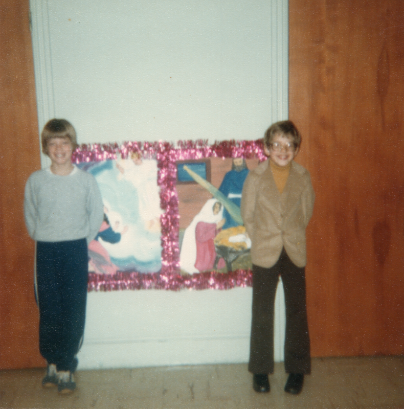 Two children pose with drawings of Jesus' birth