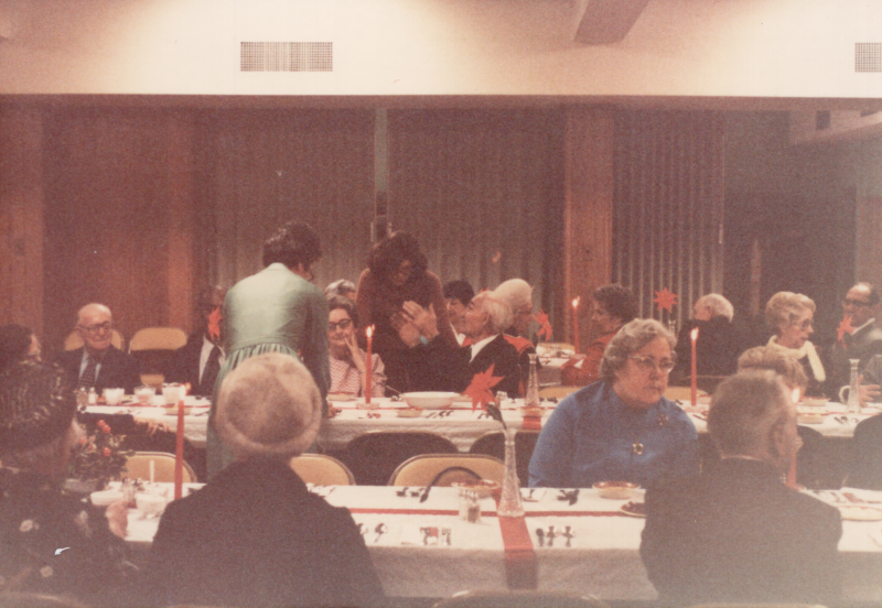 Congregants dine together at tables decorated for Christmas