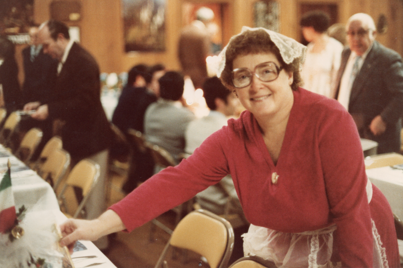 A woman serves a table that has an international flag on it
