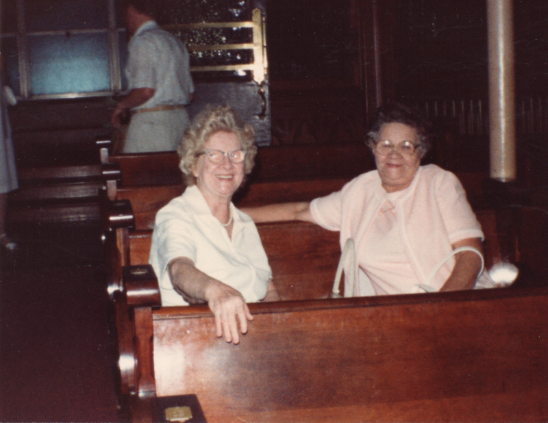 Two women smile together in the back of Highway's sanctuary