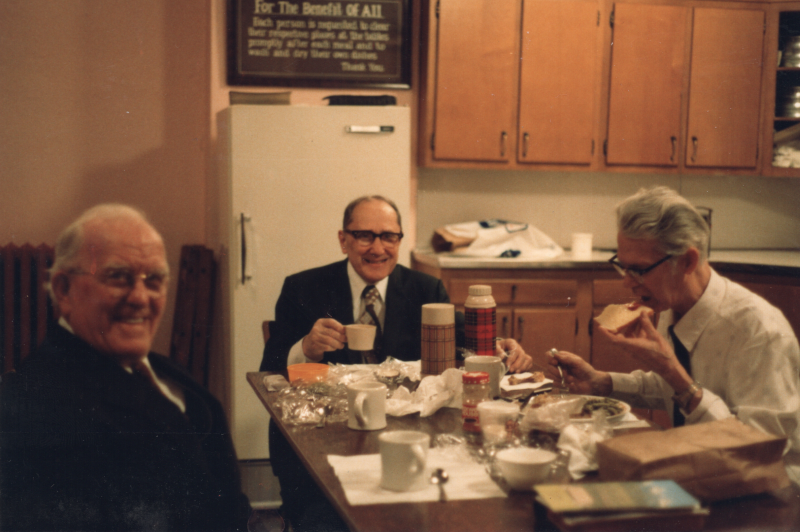 Three older men eat together in Highway's kitchen