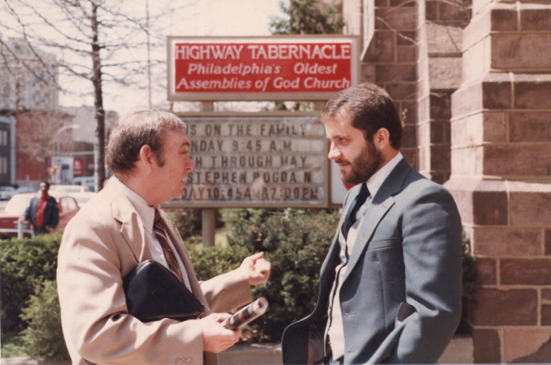 Two men speak outside of the building at 18th and Spring Garden Sts.