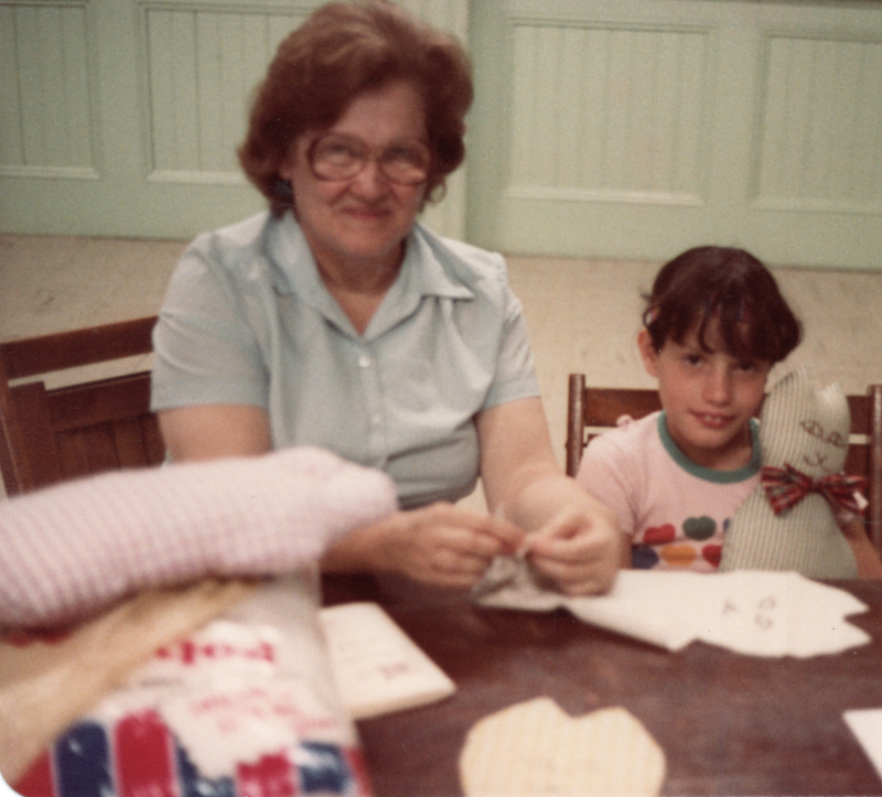 Mrs. Bogdan works on a craft with a young girl
